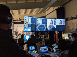 behind the AV tech table where staff are monitoring a livestreaming broadcast