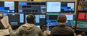 A live stream director and live stream engineer work in a studio control room as they produce a virtual event
