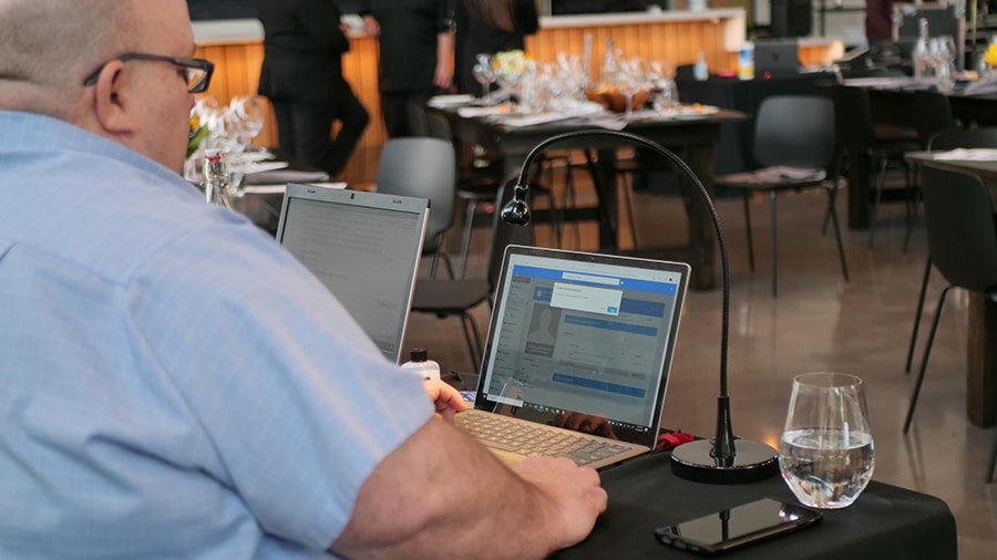 An event strategist monitors online bidding during a hybrd event