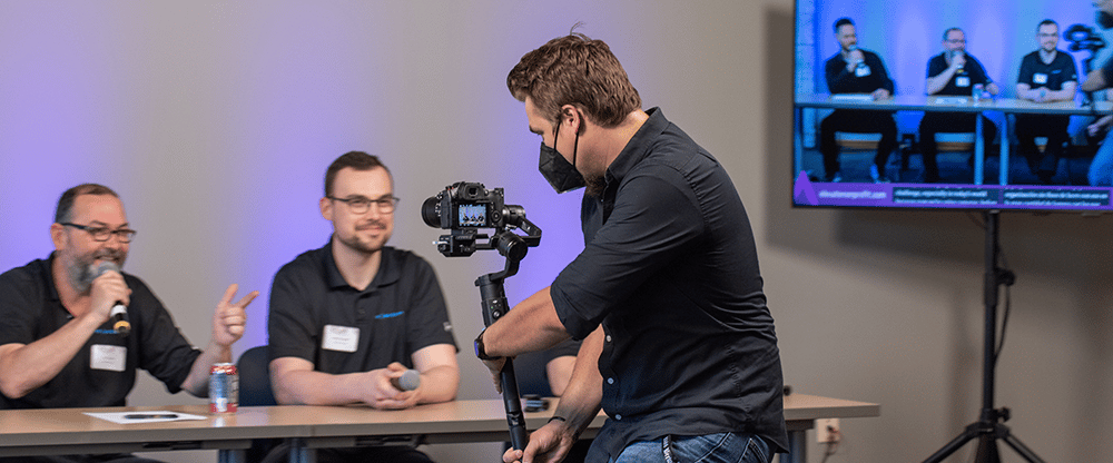 A videographer films a conference panel for a sizzle reel. Photo by Andie Petkus.