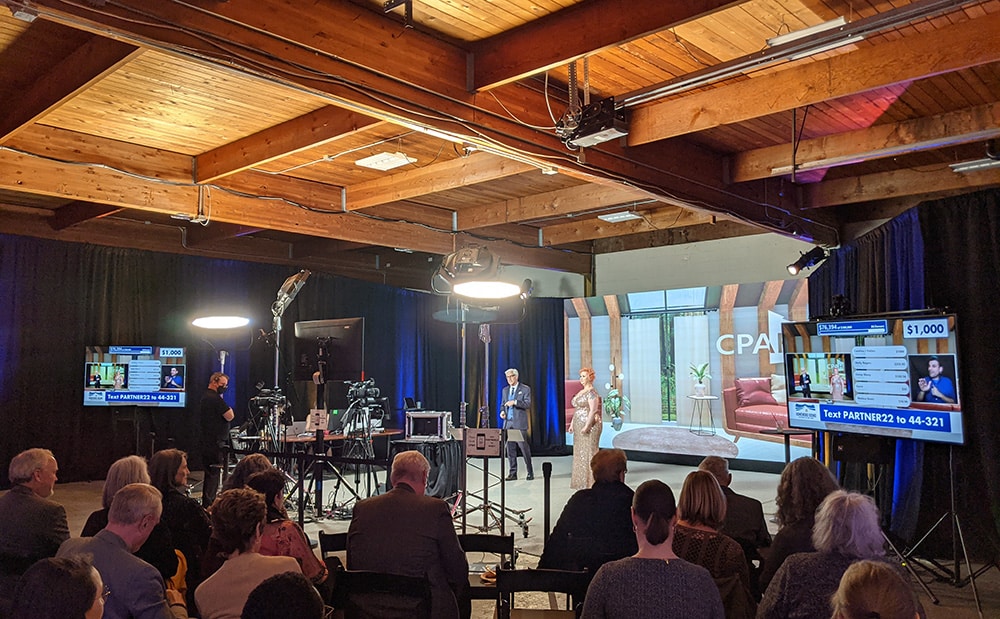An audience watches a virtual event be live streamed from a studio