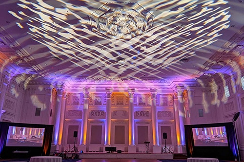 Uplights and gobos decorate a ballroom set for a live event production